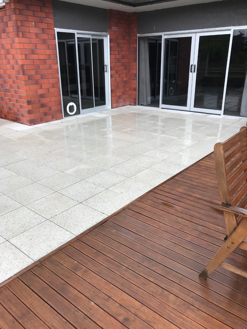 Finished light-coloured patio paving beside a timber deck