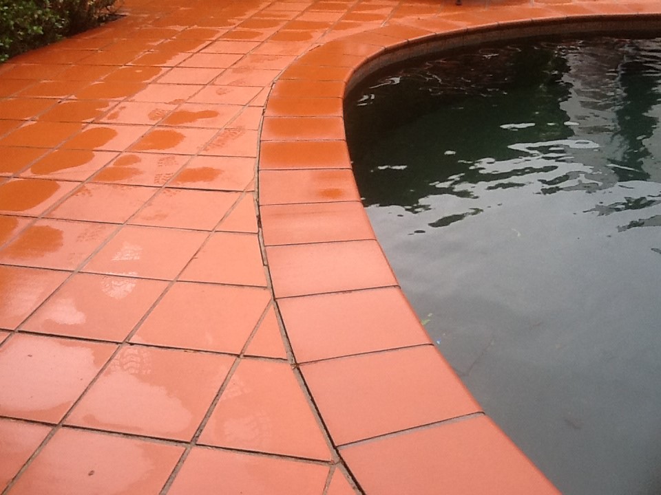 Terracotta paving around a curved swimming pool